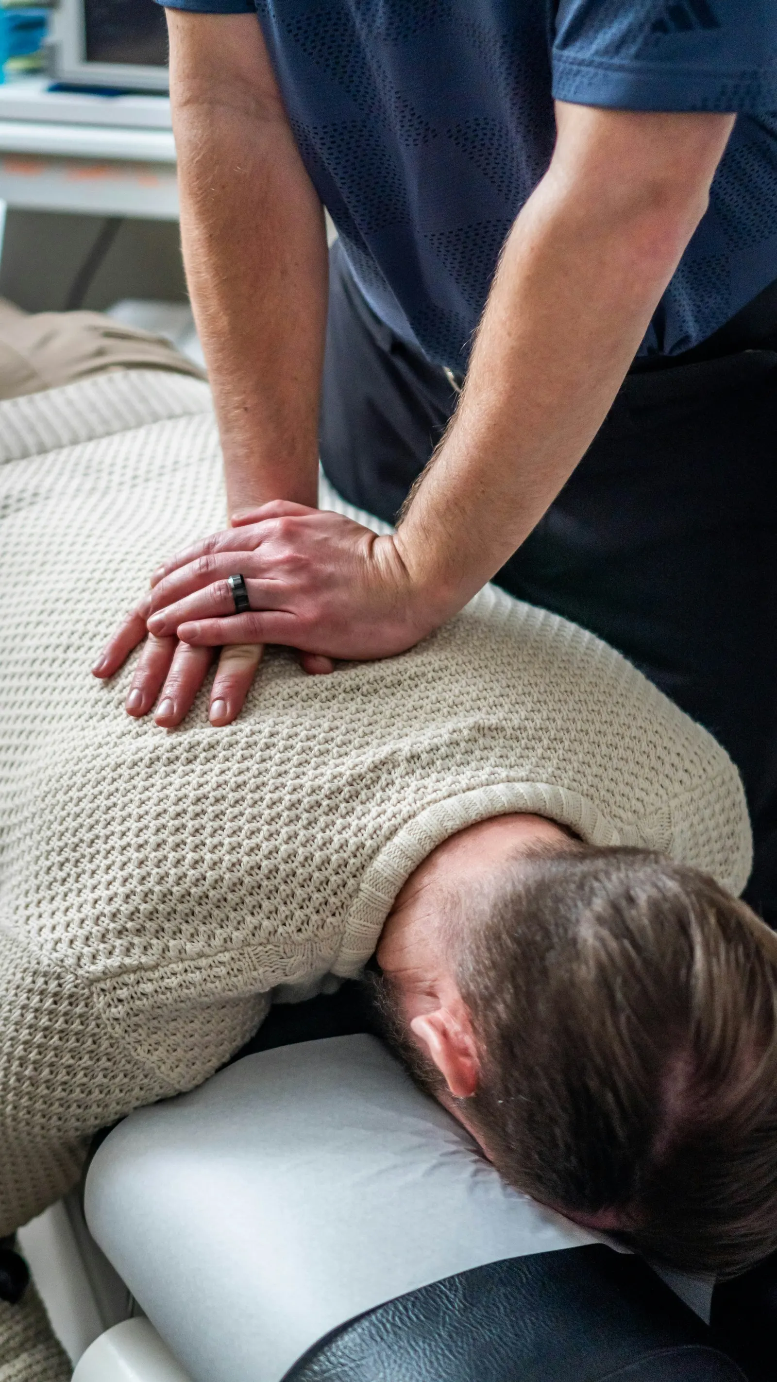 A chiropractor's hands positioned on a patient's back during treatment