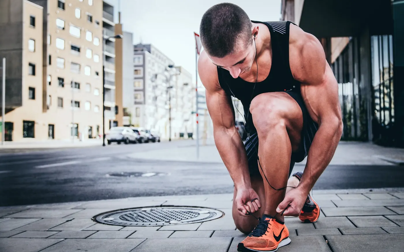 A runner lacing up their shoe before a run